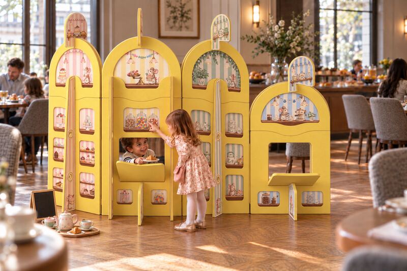 Two children playing in a yellow Kids Cafe play-screen in a hotel restaurant